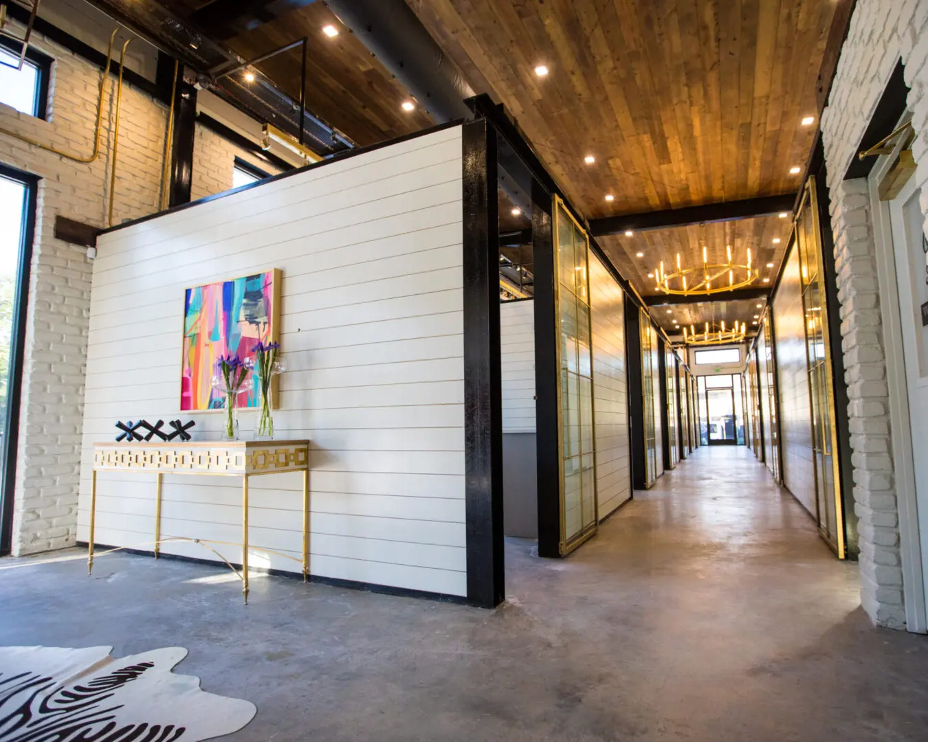 A black and white office with a glass door and lights all around